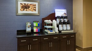 A hotel reception area with a counter displaying coffee makers, hot water dispensers, and a sign for 'Smart Roast'. - Holiday Inn Express & Suites Minot by IHG (Minot)