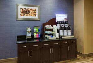A hotel reception area with a counter displaying coffee makers, hot water dispensers, and a sign for 'Smart Roast'. - Holiday Inn Express & Suites Minot by IHG (Minot)