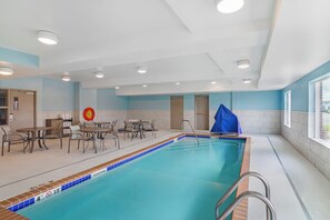 An indoor swimming pool with a tiled edge, a lifebuoy, and a covered area. - Holiday Inn Express & Suites Minot by IHG (Minot)