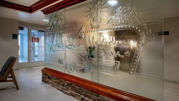 A reception area with a glass wall featuring a decorative design and the text "Holiday Inn Express."