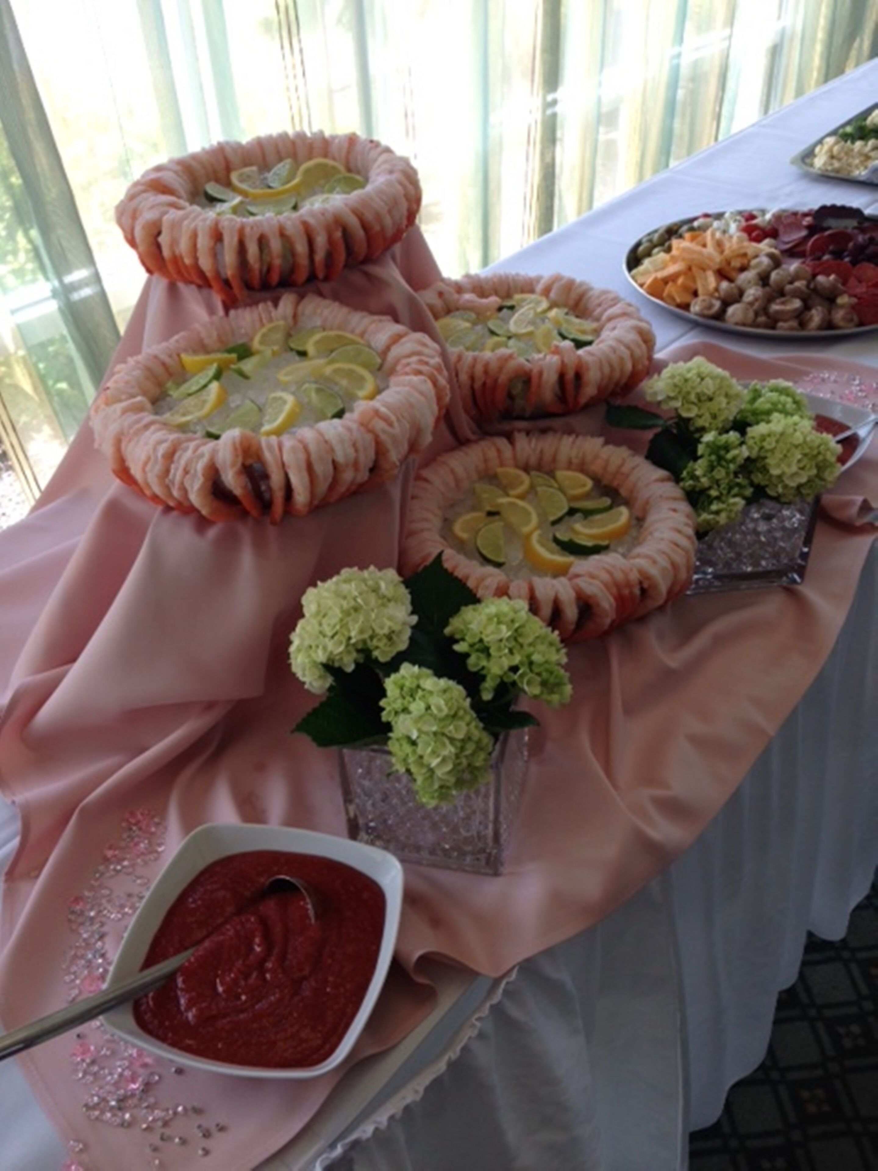 Une table sur laquelle on trouve divers aliments, notamment un bol de sauce rouge et une assiette de collations.