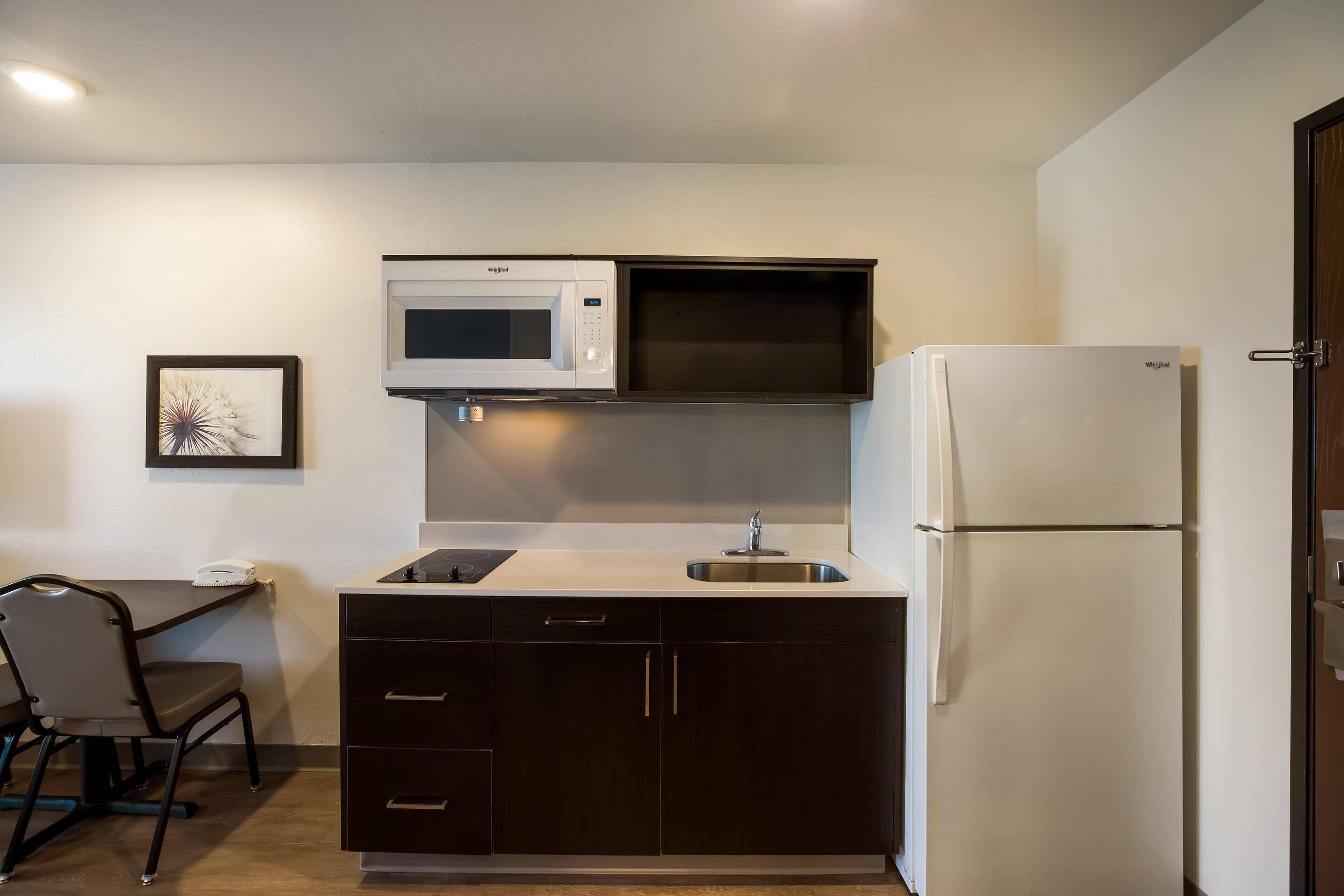 A compact kitchen with a microwave, a sink, and a refrigerator.