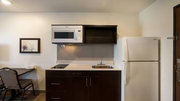 A compact kitchen with a microwave, a sink, and a refrigerator.