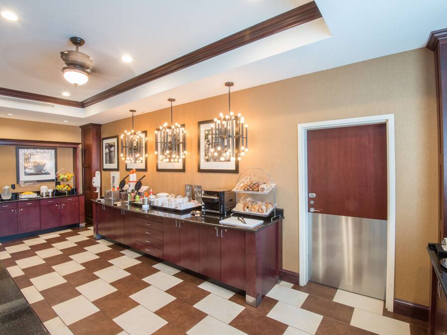 Ein Hotel-Rezeptionsbereich mit Check-in-Schalter, einem Kühlschrank und einer Kaffeestation.