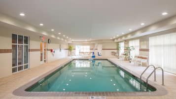 Una piscina techada, sillones reclinables de piscina