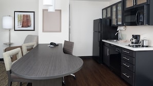 Una cocina moderna con una mesa de comedor, sillas y un refrigerador.