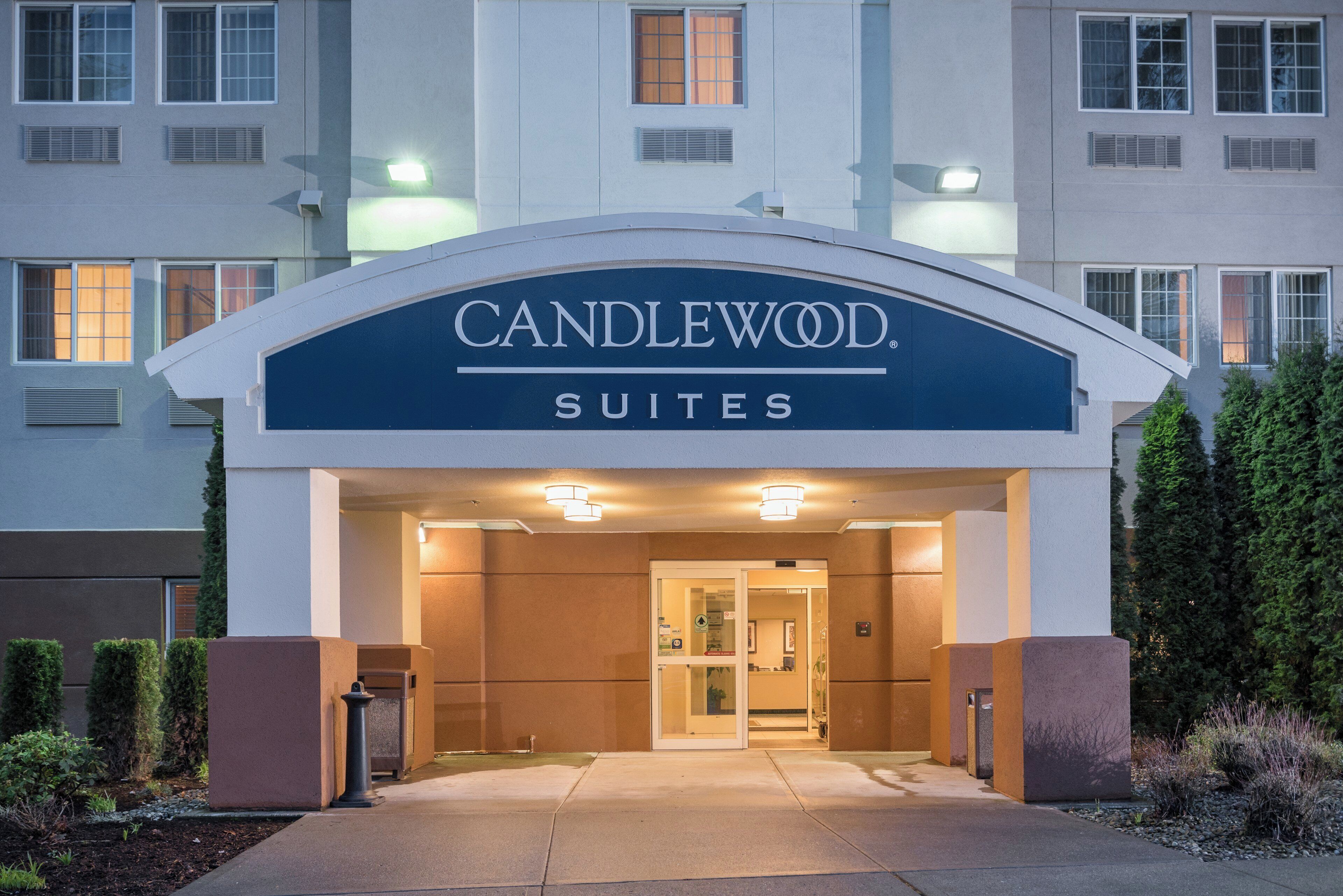 A hotel entrance with a sign reading 'CANDLEWOOD SUITES'.