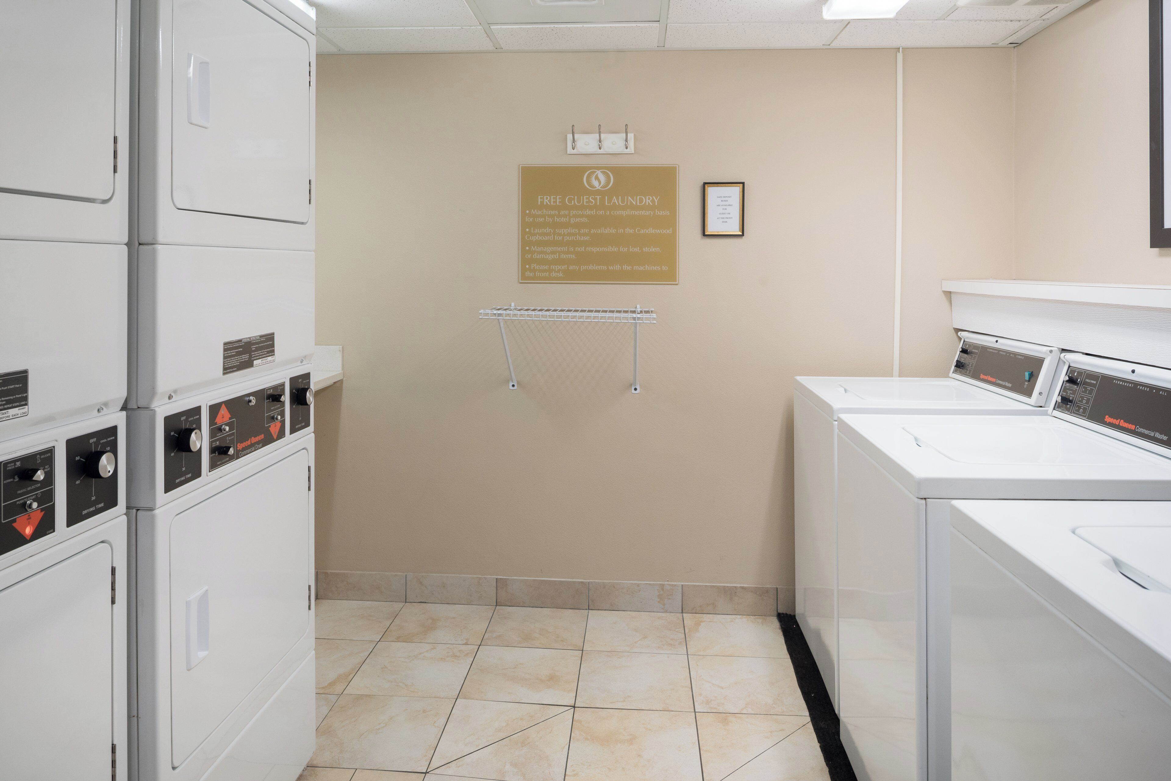 Zona de lavandería con varias lavadoras, disponible para huéspedes del hotel, y aviso sobre la falta de responsabilidad de la administración por objetos perdidos.