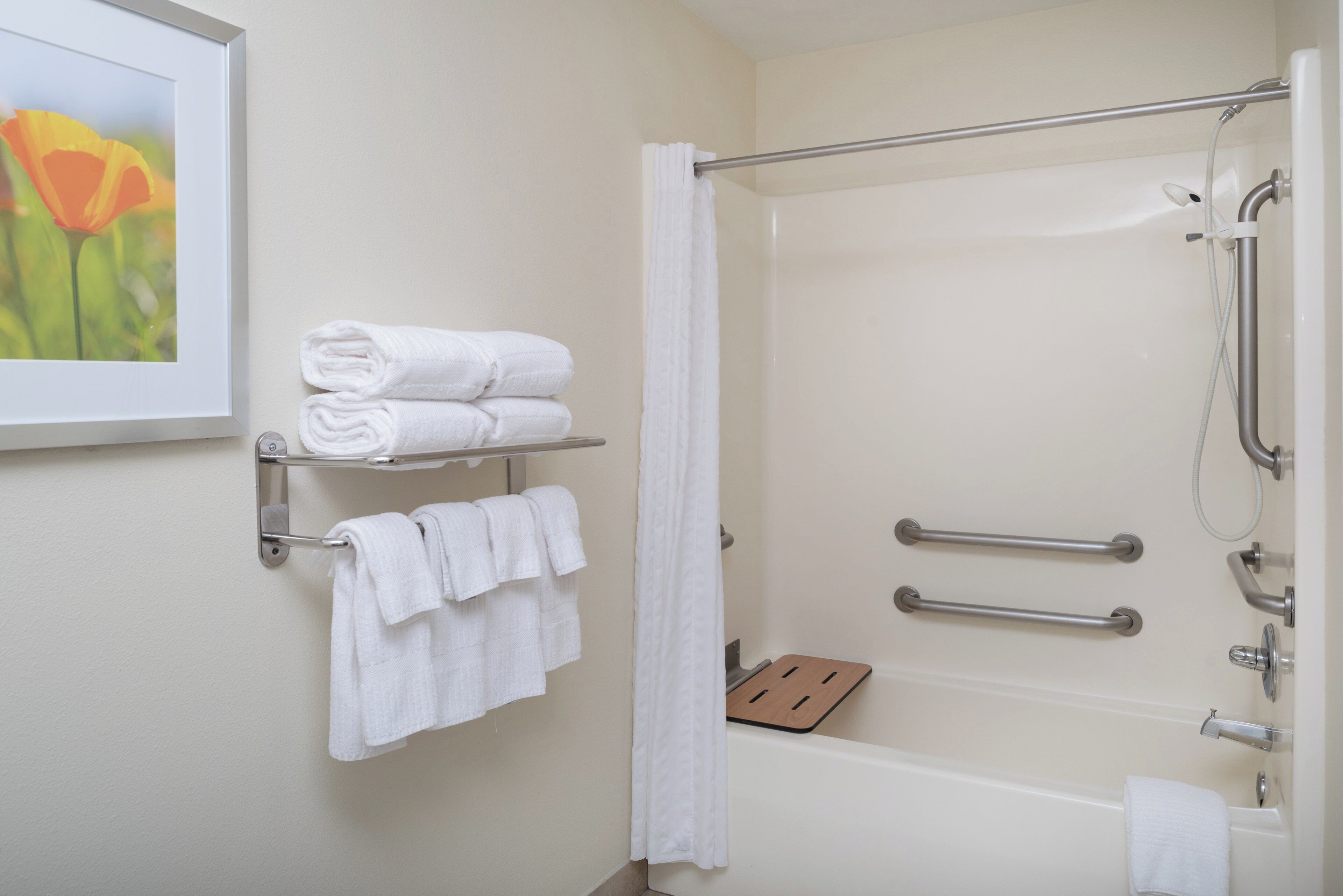 Une salle de bain équipée d’une douche, d’une baignoire et d’un porte-serviettes avec des serviettes pliées.