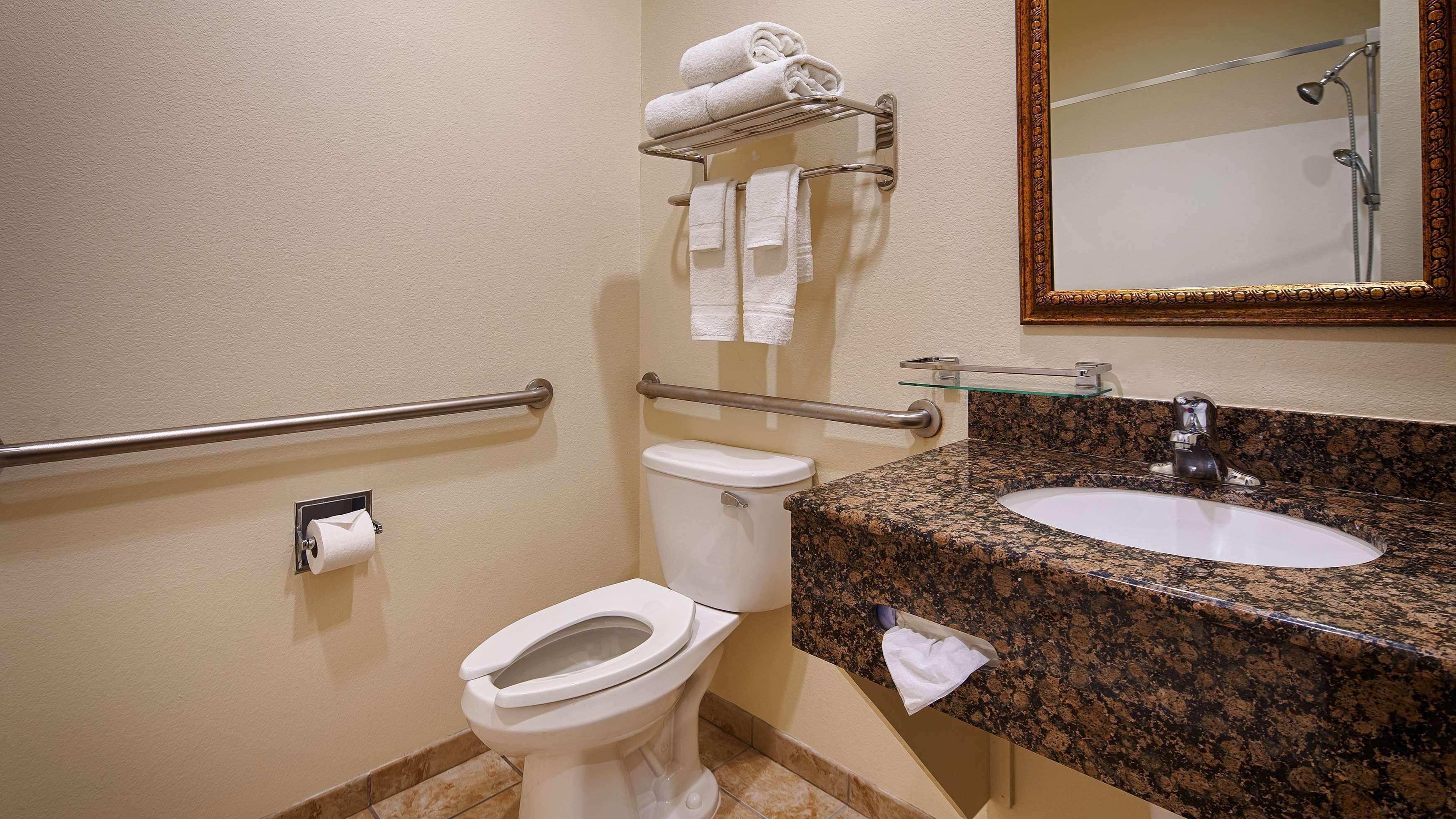 A bathroom with a toilet, a sink, a towel rack, and a shower.