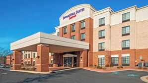 Un hôtel à la façade en briques, doté d’une entrée couverte et d’une enseigne indiquant « Springhill Suites ».