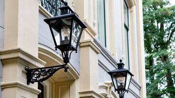 Fachada de edificio con farolas de metal negro ornamentadas y estilo arquitectónico clásico.