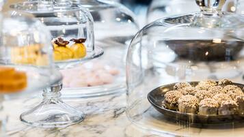 A display of desserts under glass domes on a marble countertop.
