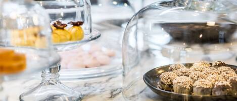 A display of desserts under glass domes on a marble countertop.