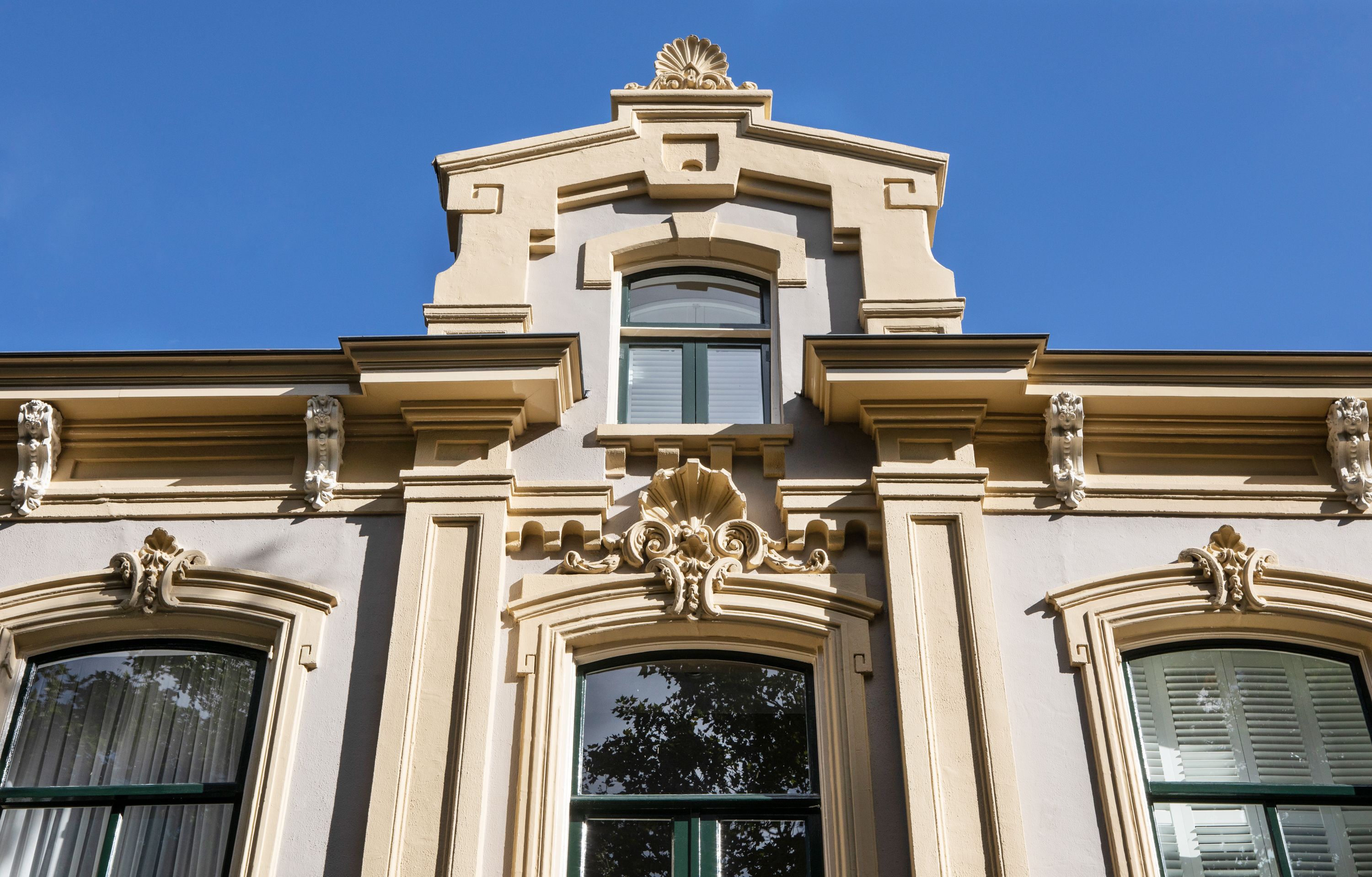 Un edificio con detalles arquitectónicos ornamentales, incluyendo molduras decorativas y estatuas.