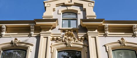 Un edificio con detalles arquitectónicos ornamentales, incluyendo molduras decorativas y estatuas.