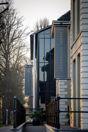 A modern building with a sign for 'IJssel Restaurant' and 'Pillows Hotel'.