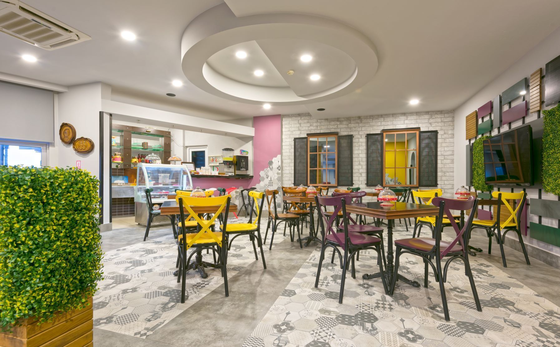 Un restaurante con una decoración moderna, que ofrece diversas opciones de asientos y una pared de ladrillo como detalle decorativo.
