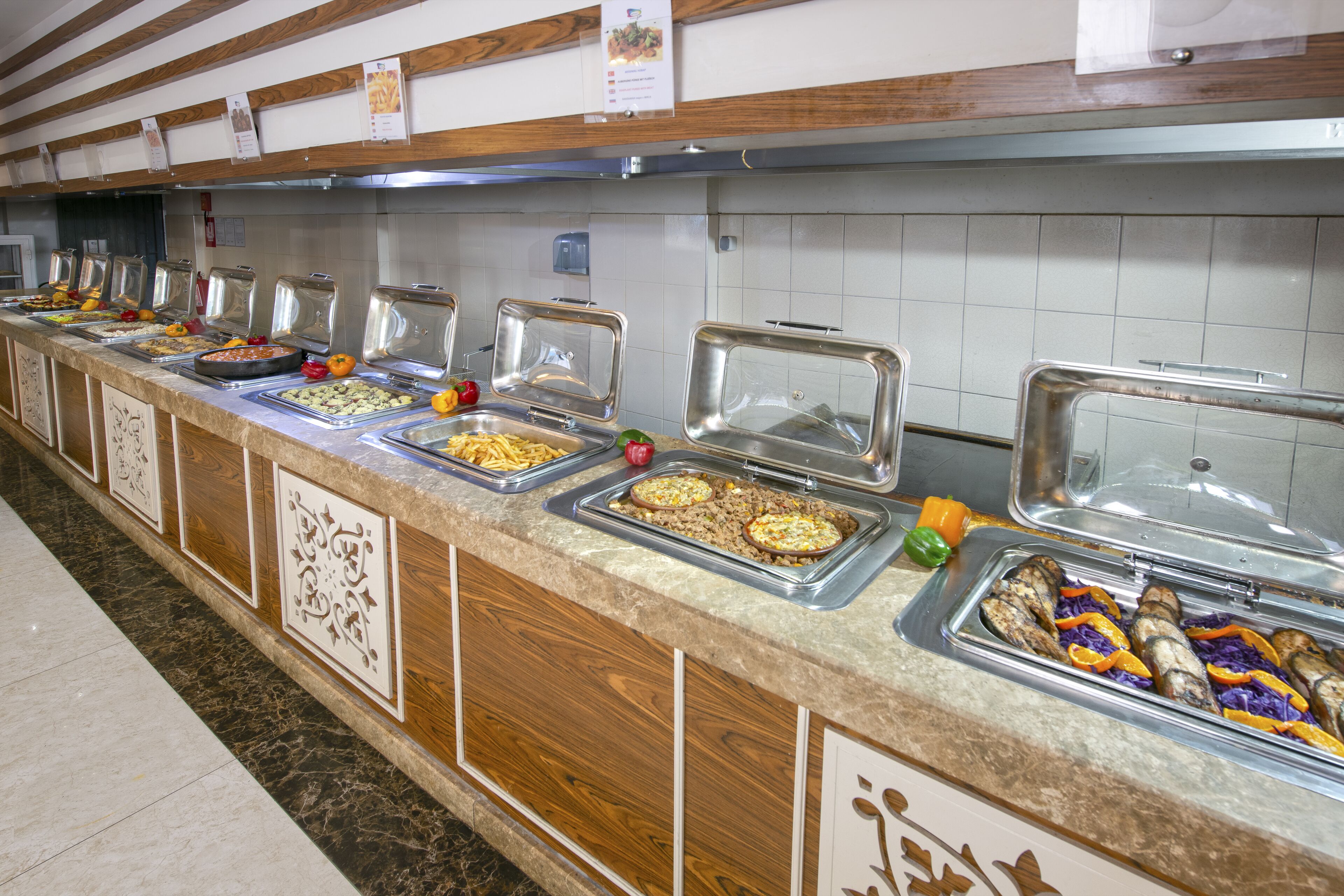 Un banco buffet con diversi cibi esposti in contenitori.