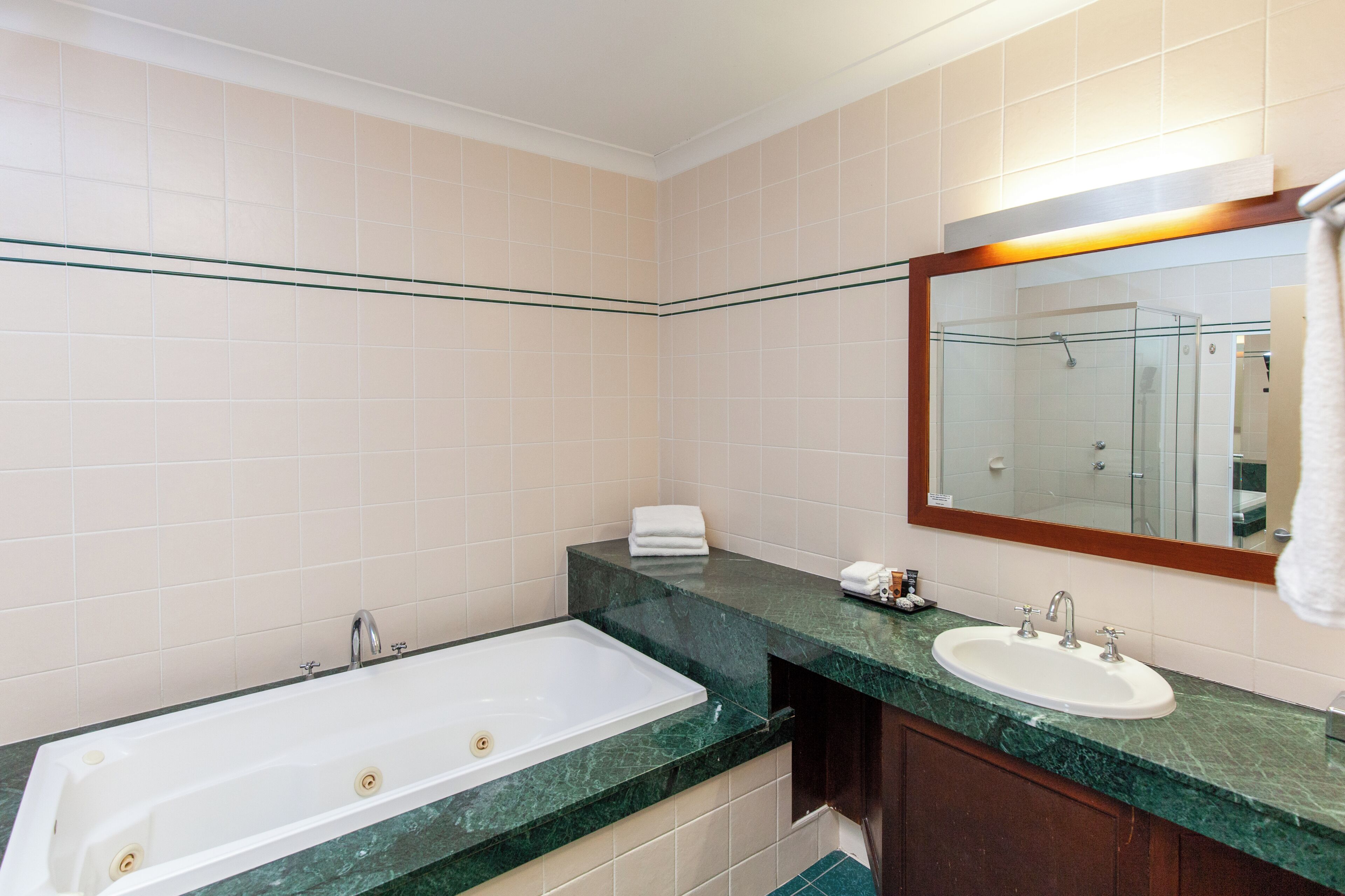A modern bathroom with a bathtub, sink, and mirror.