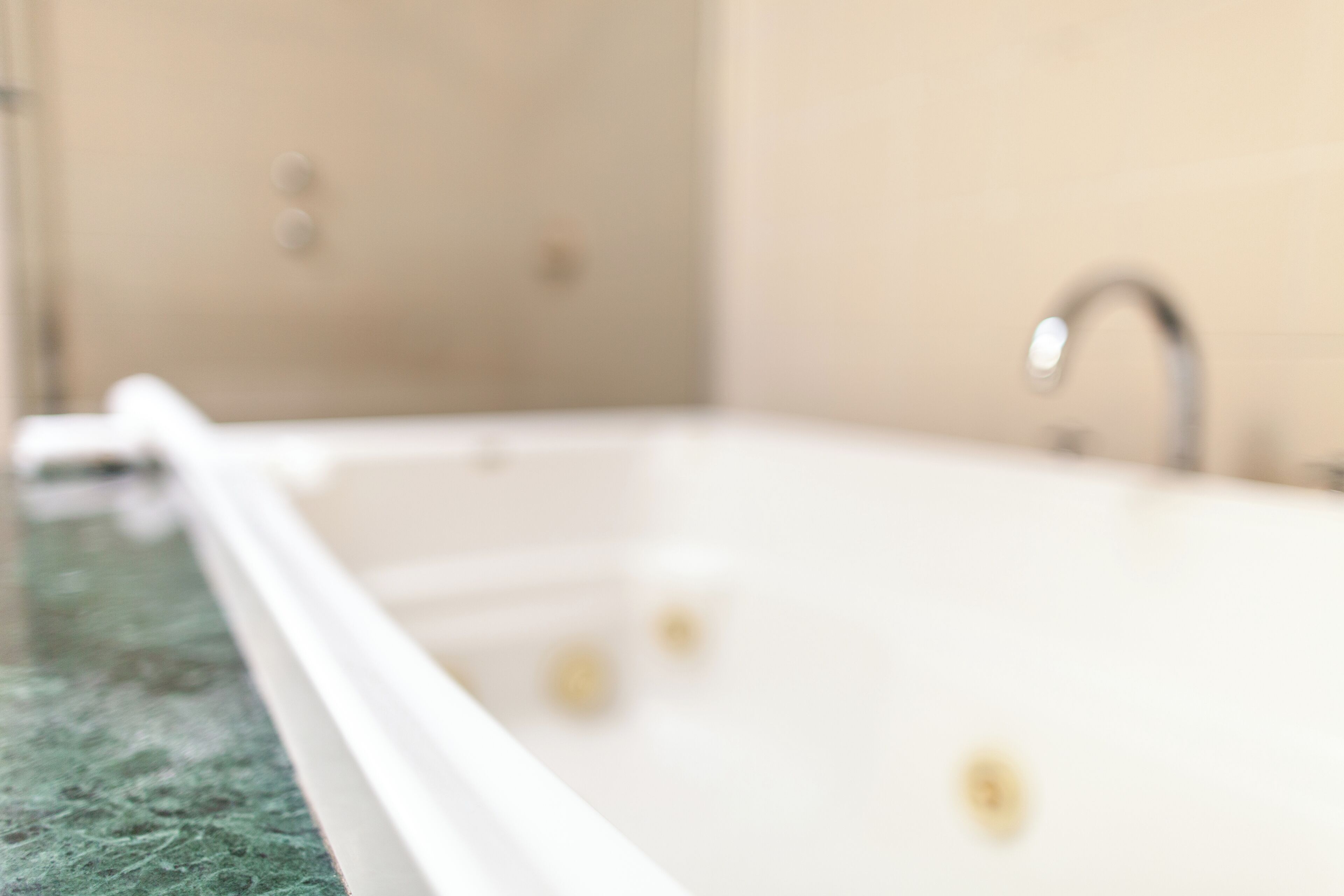A bathroom with a bathtub, a sink, and a mirror.