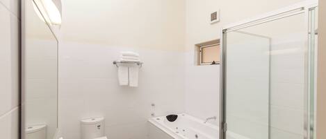 A modern bathroom with a glass shower enclosure, a white sink, and a mirror.