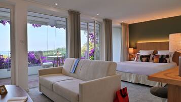 Suite Junior, vue mer | Área de sala de estar | Televisión de 70 cm con canales vía satélite