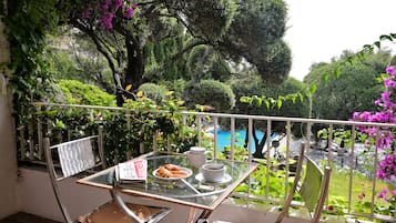 Enjoy a peaceful breakfast on the balcony overlooking the beautifully maintained garden and pool.