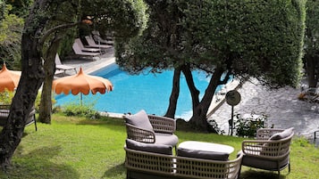 A poolside area with wicker furniture and umbrellas.