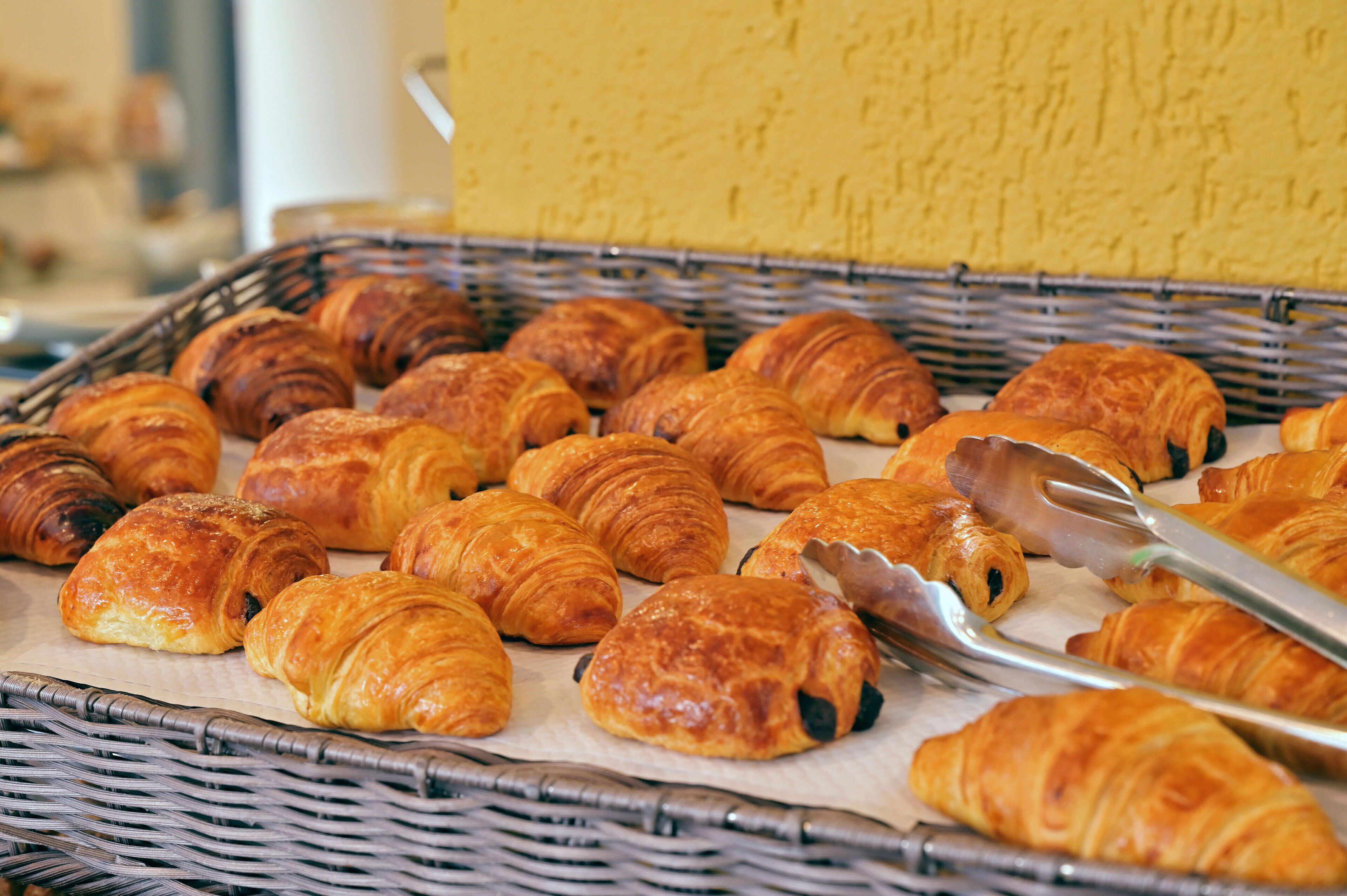 A basket filled with assorted pastries, including croissants and other baked goods.