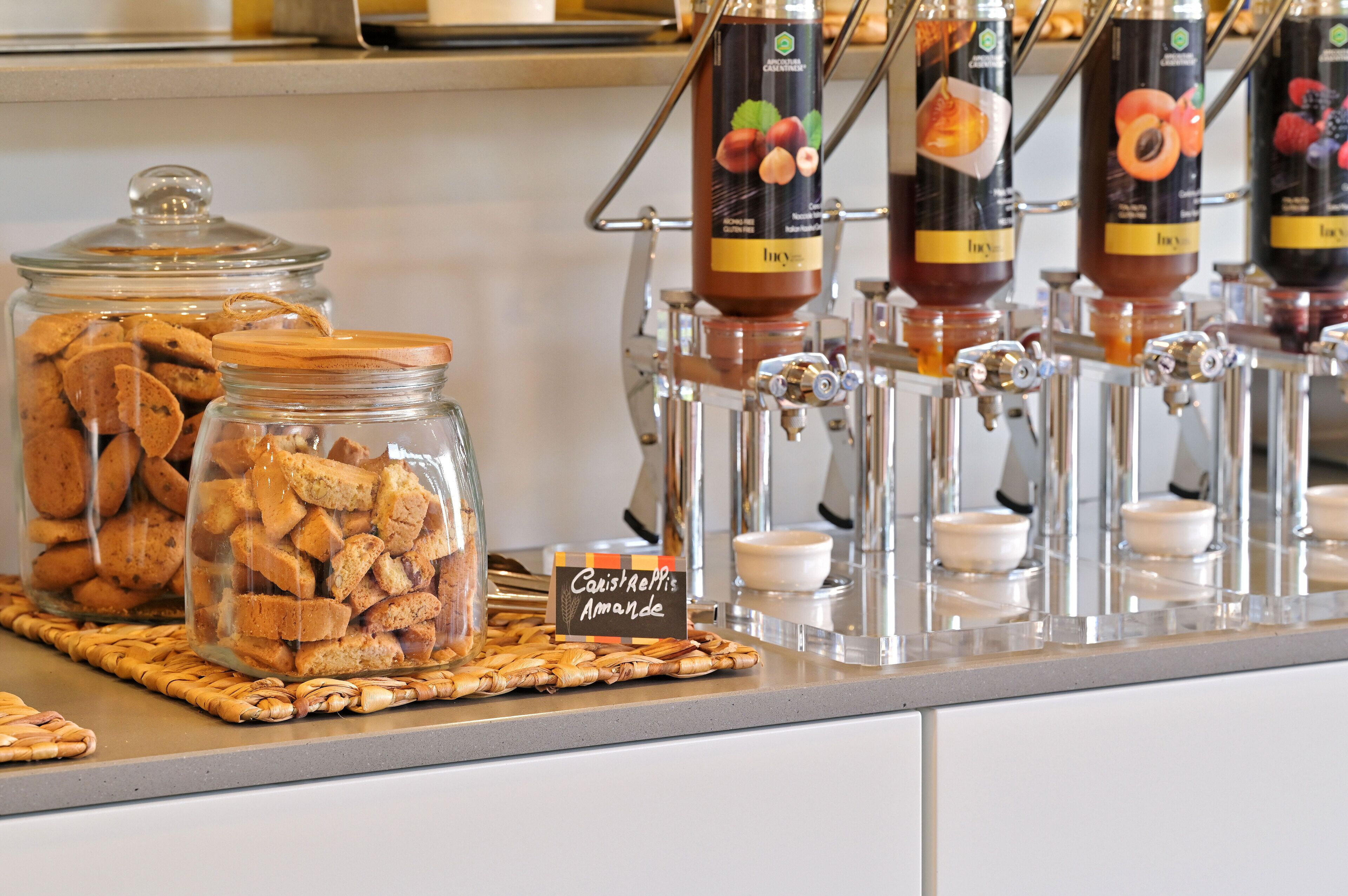 A buffet with jars of cookies and a sign for 'Café Reps Amande'.