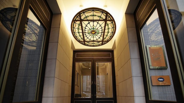 A hotel entrance with a glass door, a decorative glass ceiling, and a tiled floor. - Hotel Monterey La Soeur Ginza (Tokyo)