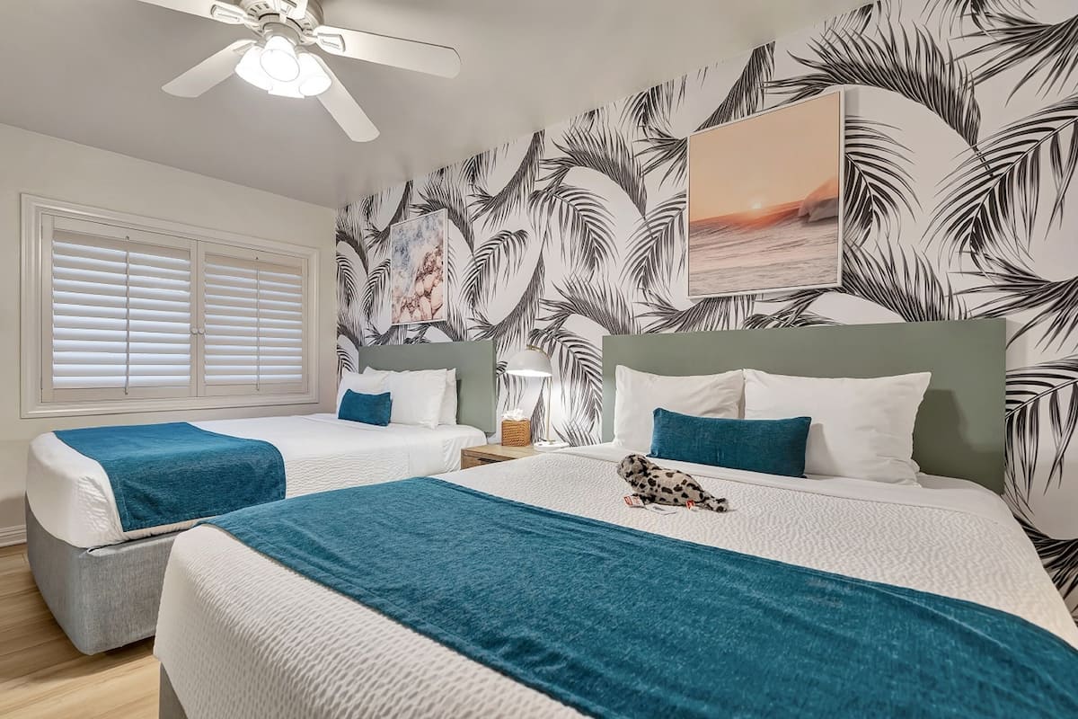 Habitación Deluxe, 2 camas de matrimonio | Escritorio, tabla de planchar con plancha, wifi gratis y ropa de cama