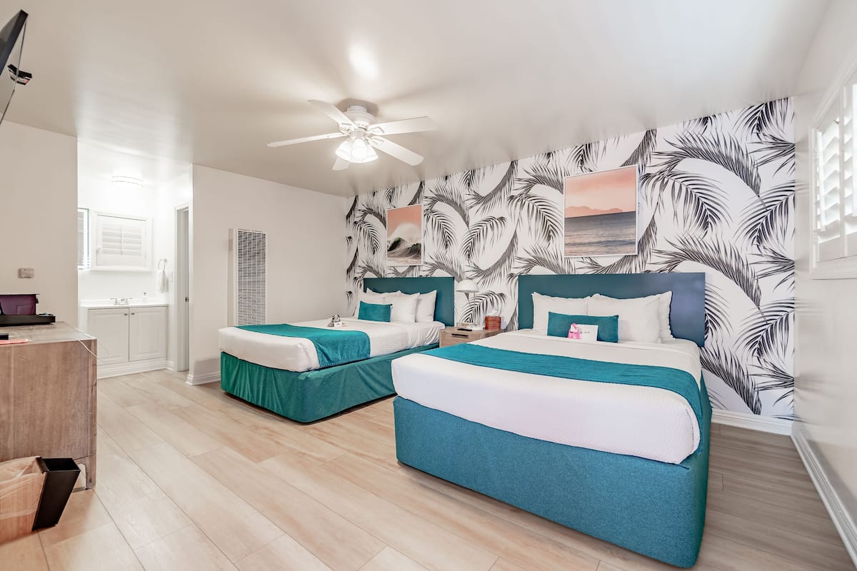 Habitación Deluxe, 2 camas de matrimonio | Escritorio, tabla de planchar con plancha, wifi gratis y ropa de cama