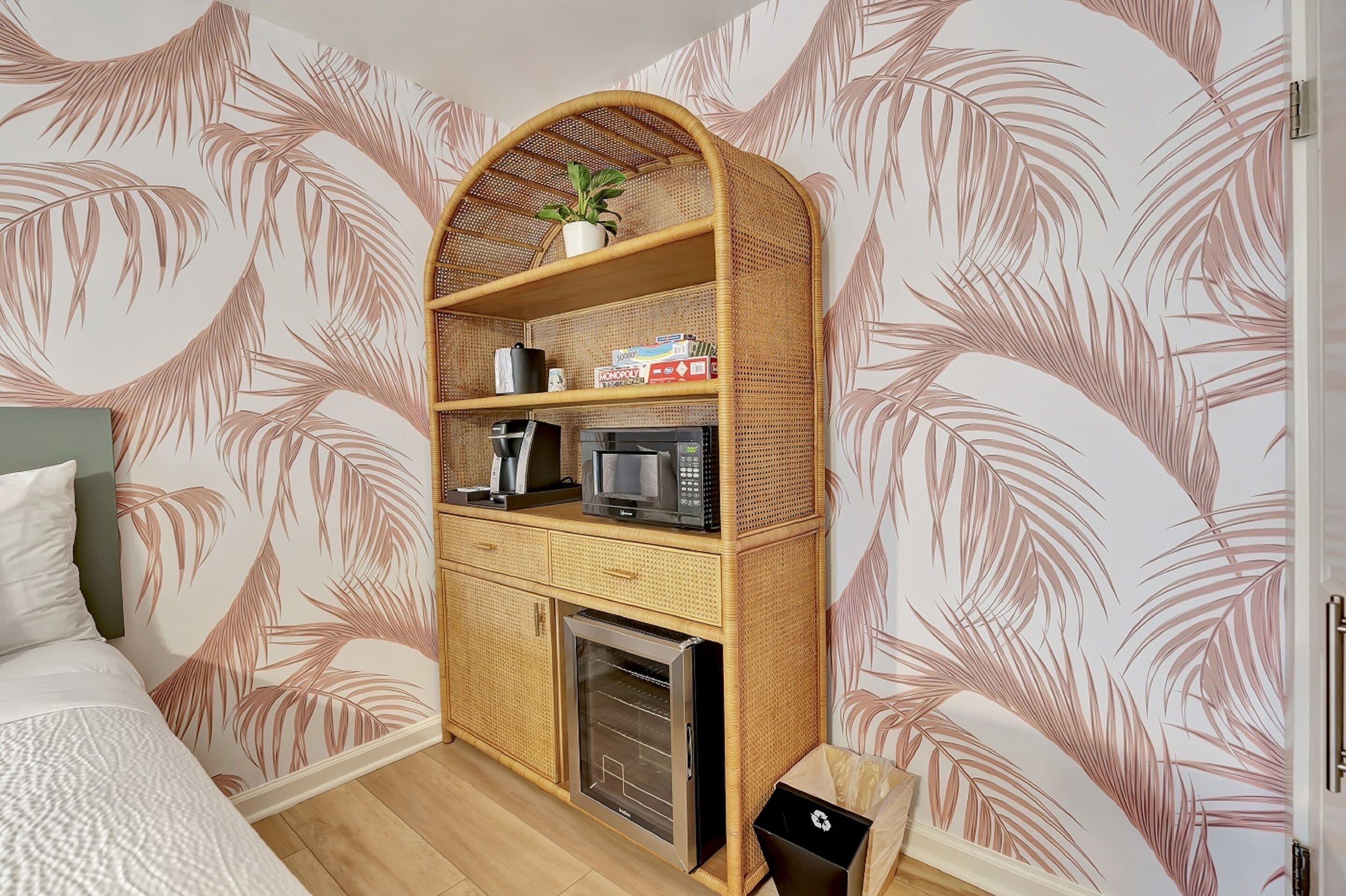 Une chambre compacte comprenant un lit, une kitchenette équipée d’un four à micro-ondes, d’une machine à café et d’un petit réfrigérateur.