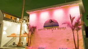 A hotel entrance with a palm tree, two benches, and a staircase leading up. - Santa Monica Hotel (Santa Monica)