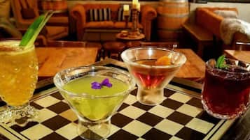 Un espace bar avec un sol à carreaux, une variété de boissons servies dans différents types de verres, et un mur de briques en arrière-plan.