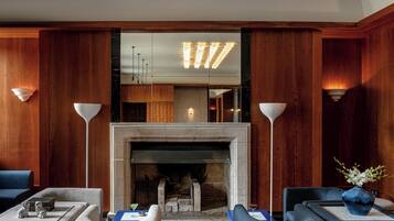 A modern living room with a fireplace, wooden paneling, and two sofas.