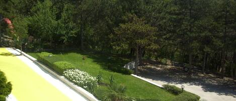 A landscaped area with a lawn, flower beds, and a paved path.