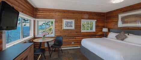 A cozy cabin room with a bed, a desk, and a chair.