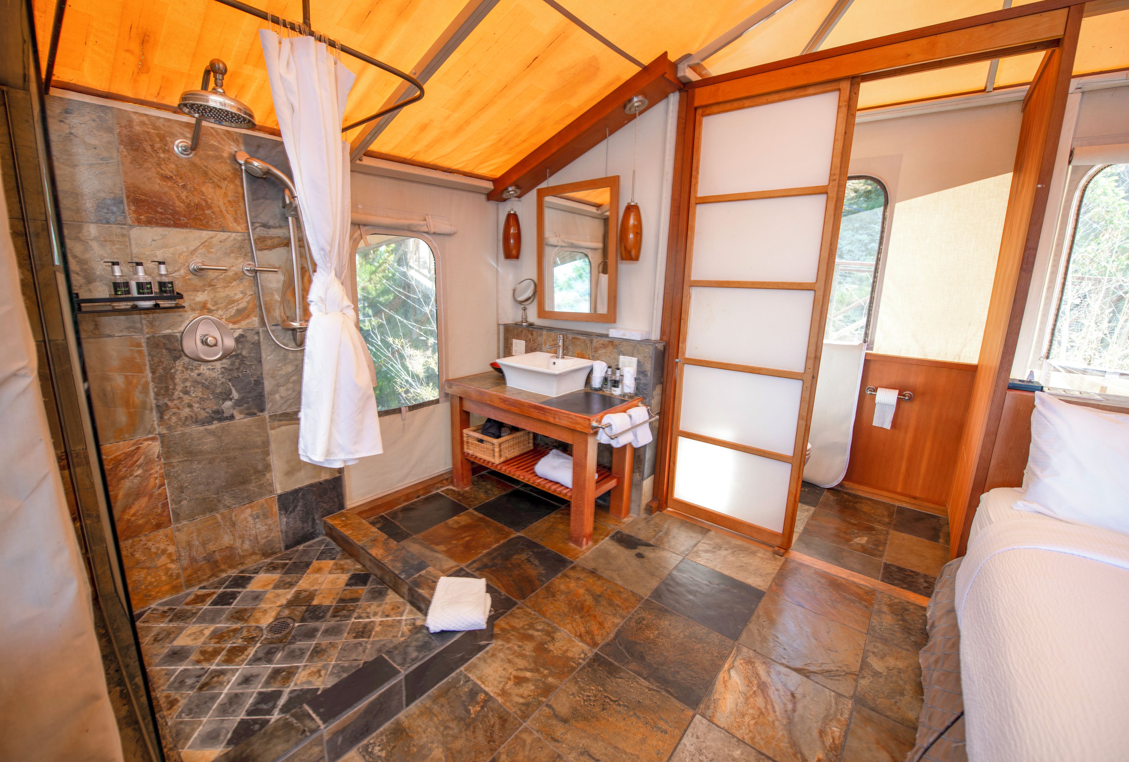 Une salle de bain avec une douche, un lavabo et un miroir.