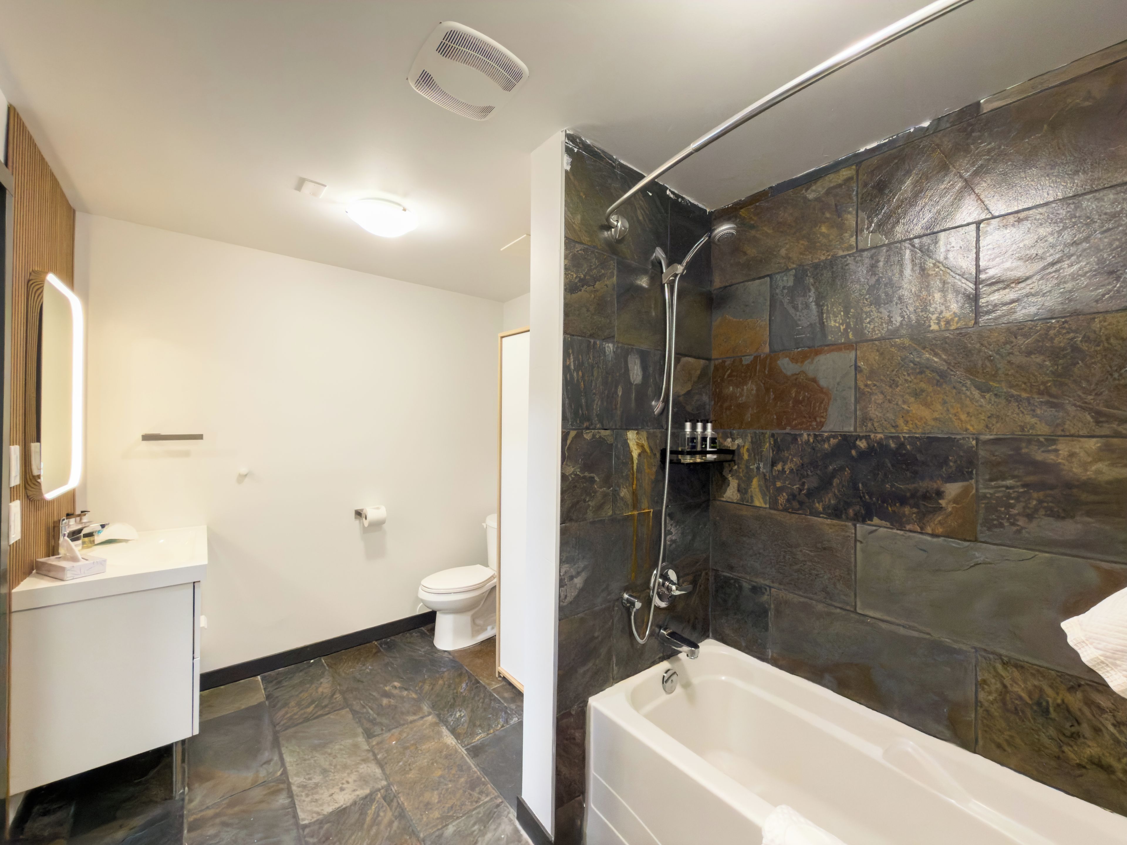 A bathroom with a shower, toilet, and sink.