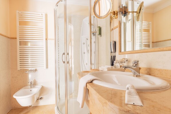 A modern bathroom with a glass shower enclosure, a sink, and a mirror.
