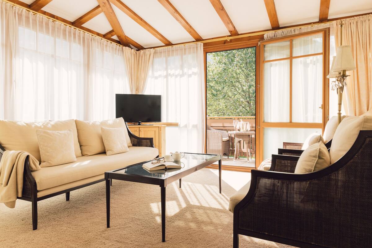 A living room with a sofa, a chair, a coffee table, and a television.