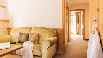 A cozy room with a yellow sofa, a wooden door, and a hallway leading to another area.