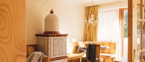 Un salon chaleureux avec un meuble en bois, un banc, une table et un lustre.