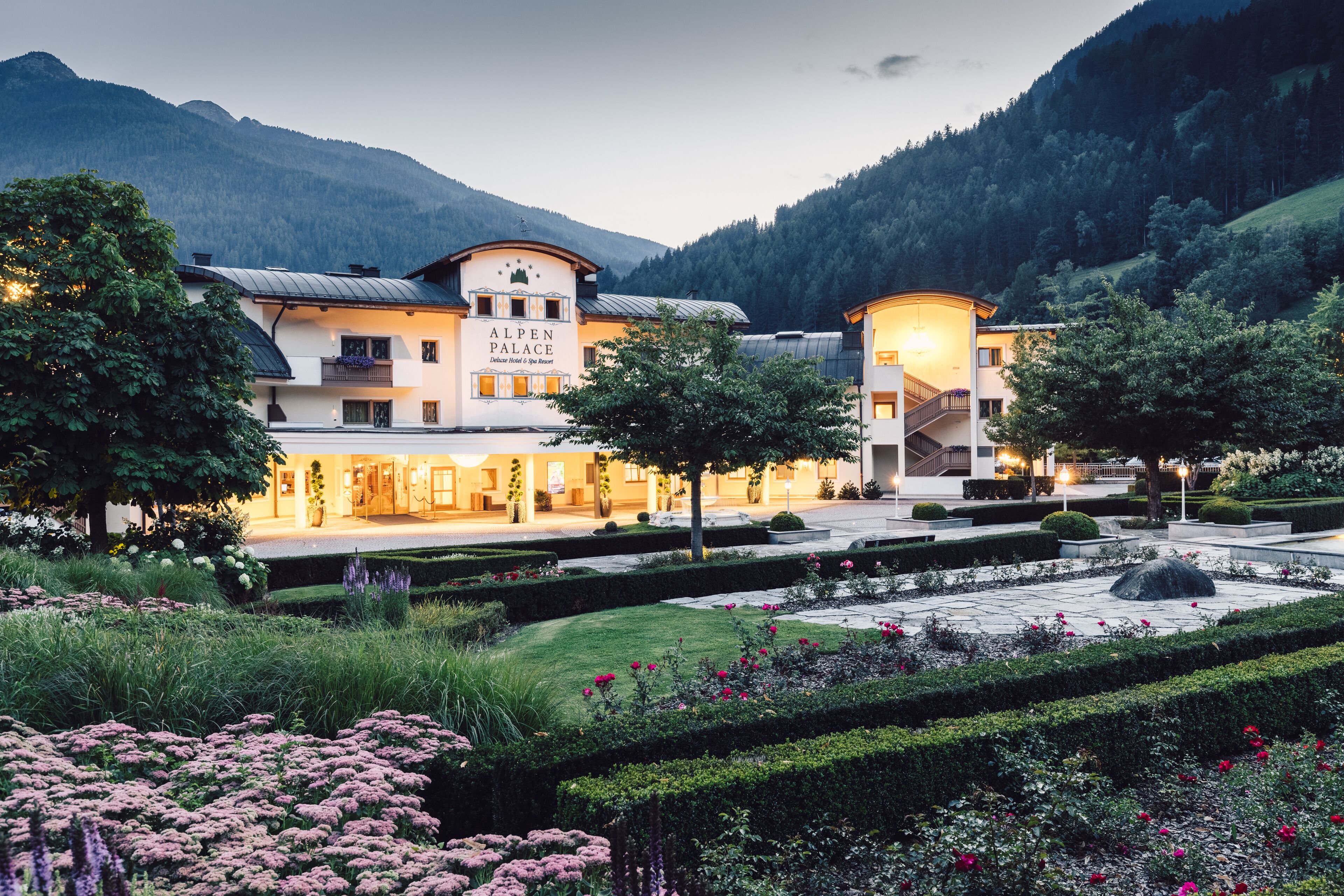 Ein Hotel mit einem zentralen Hauptgebäude und einem Gartenbereich.