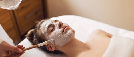 Una persona recibiendo un tratamiento facial con mascarilla.