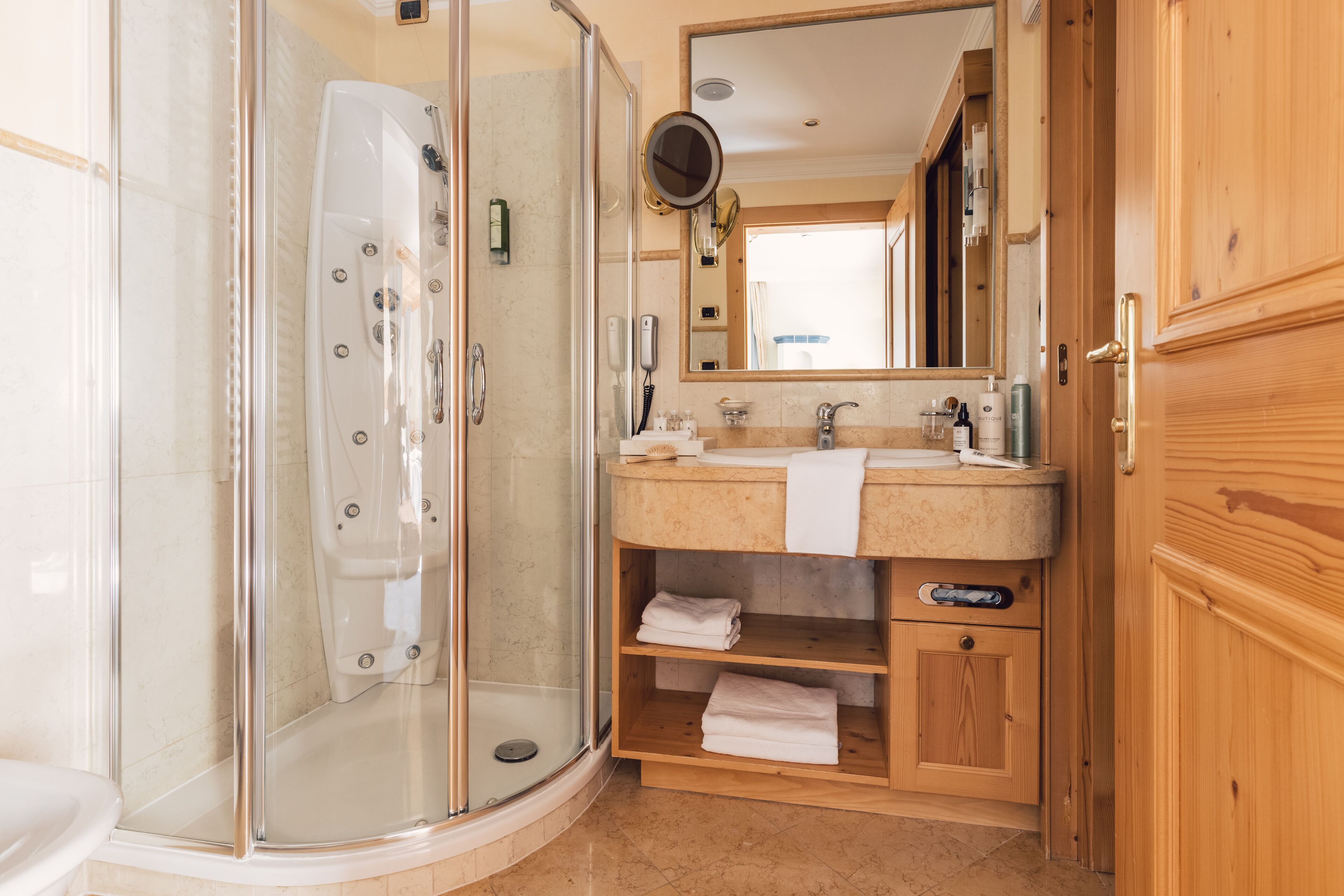 A modern bathroom with a glass-enclosed shower, a bathtub, a vanity with a sink, and a mirror.