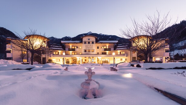 A hotel with a central fountain, snow-covered surroundings, and a mountainous backdrop. - Alpenpalace Luxury Hideaway & Spa Retreat (Valle Aurina)